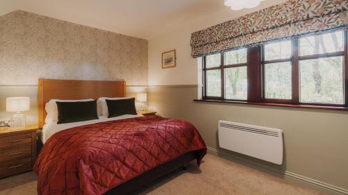 a bedroom with a bed and a window at Wansfell Cottage At Windermere Marina Village in Bowness-on-Windermere