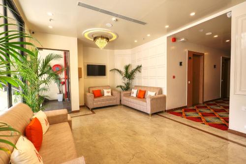 a living room with two couches and a tv at Mosaic Connect Ayodhya in Ayodhya