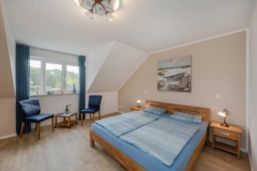 a bedroom with a bed and two chairs in it at Usedom-Idyll in Loddin