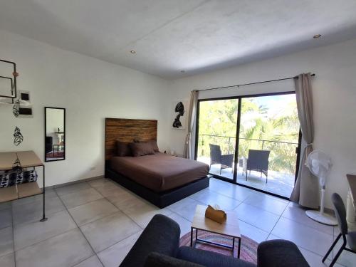 a bedroom with a bed and a living room at Casa Pavezin in Mahahual
