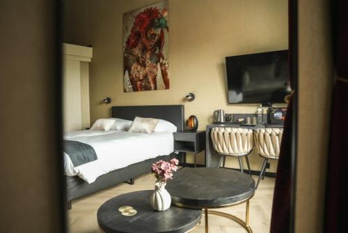 a bedroom with a bed and a table and chairs at Stadshotel Jacob Cats in Brouwershaven