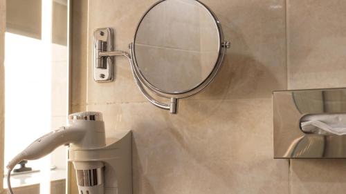 a mirror on a wall next to a sink at Terrace Alzahra تيراس الزهرا in Jeddah