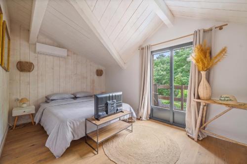 a bedroom with a bed and a television on a table at Villa typique - piscine et terrasse in La Teste-de-Buch