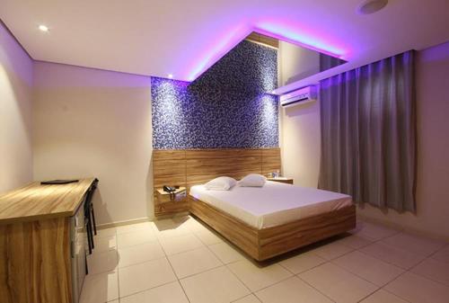 a bedroom with a bed with a purple lighting at Flow Motel (Adult Only) in Valinhos