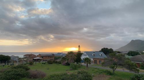 a sunset over a small town with a clock tower at Shores Keep - Self Catering Home in Hermanus