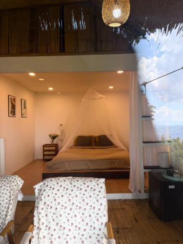 a bedroom with a bed with a canopy at อะบู้ศรีโฮมสเตย์ in Ban Huai Khai