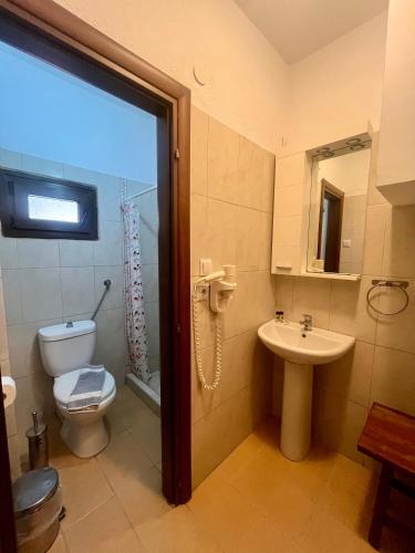 a bathroom with a toilet and a sink at The Beach House - Apartments & Studios in Afitos