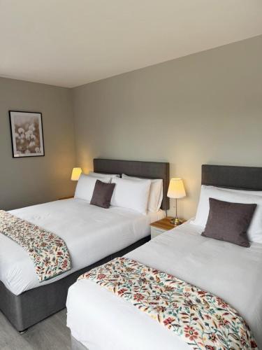 a hotel room with two beds and two lamps at Balreask Bar, Restaurant & Guest Accommodation in Navan