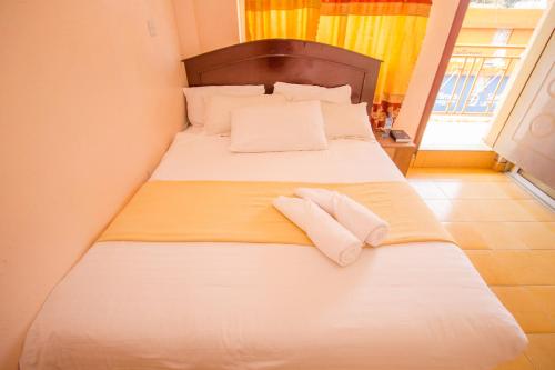 ein Schlafzimmer mit einem Bett mit zwei Handtüchern darauf in der Unterkunft Eland Safari Hotel Nyeri in Nyeri