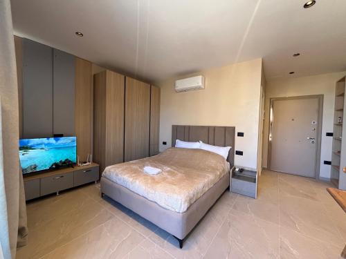 a bedroom with a bed and a flat screen tv at Ciel Apartement in Orikum