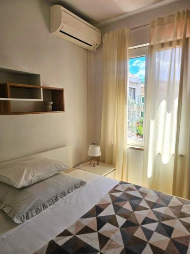 a bedroom with a large bed and a window at Apartmani Banić Apartman Studio 3 in Postira