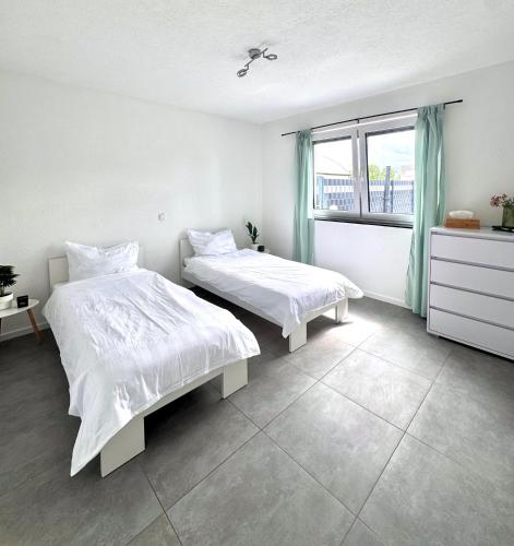 two beds in a white room with a window at KiNi Unterkunft in Hörstel