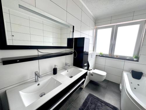 a white bathroom with a sink and a toilet at KiNi Unterkunft in Hörstel