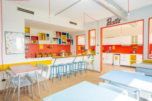 a classroom with tables and chairs and a counter at Ostello Bello Milano Centrale in Milan
