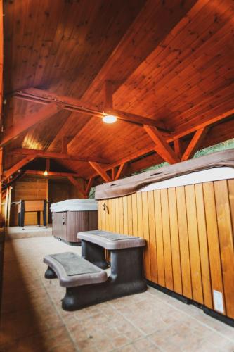 two benches in a building with wooden ceilings at Eged Panzió Eger in Eger