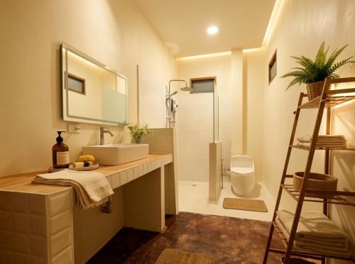 a bathroom with a sink and a mirror and a shower at Thara Pearl Villa in Ko Phangan