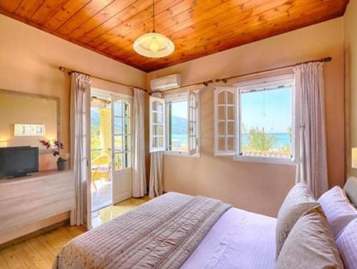 una camera con un grande letto e finestre di Caramela Beach House ad Agios Georgios Pagon