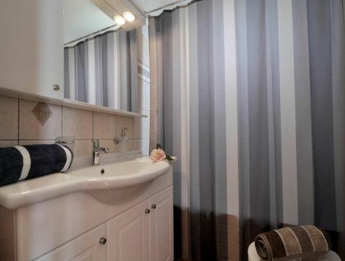 a bathroom with a sink and a shower curtain at Caramela Beach House in Agios Georgios Pagon