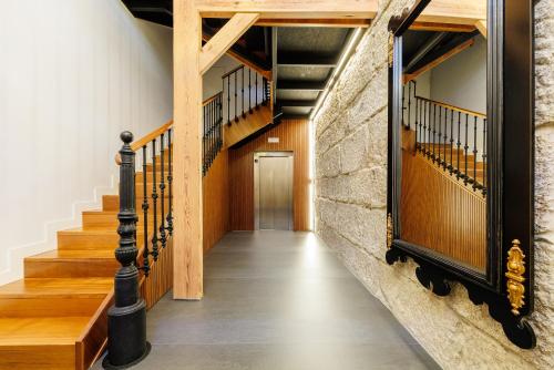 a hallway with wooden stairs and a brick wall at YBH Mare Boutique in Vigo