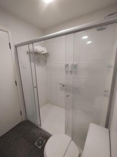 a bathroom with a toilet and a glass shower at Marques Plaza Hotel in Pouso Alegre