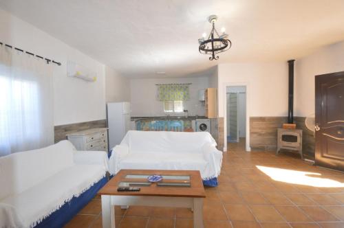 a living room with a white couch and a table at Casa Samuel con piscina comunitaria y porche in Cádiz