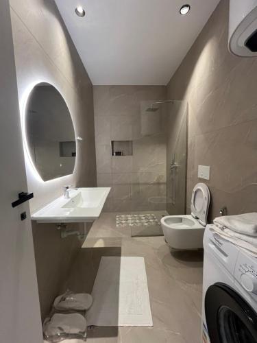 a bathroom with a sink and a toilet at Ciel Apartement in Orikum