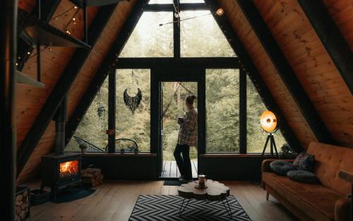 a woman standing in a room with a window at Two Black Cabins in Pabaži