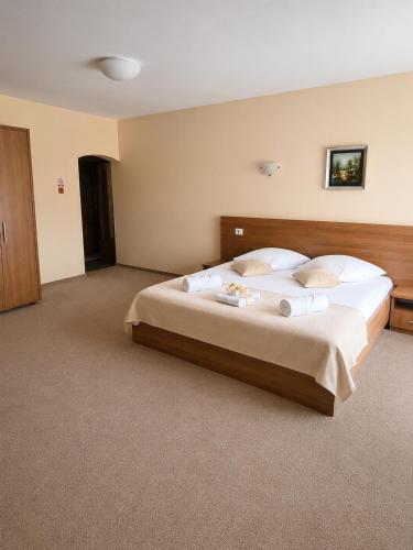 a bedroom with a large bed with white sheets and pillows at Motel Casa Stimatu in Bărcăneşti