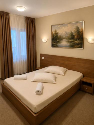 a bedroom with a large bed with a painting on the wall at Motel Casa Stimatu in Bărcăneşti