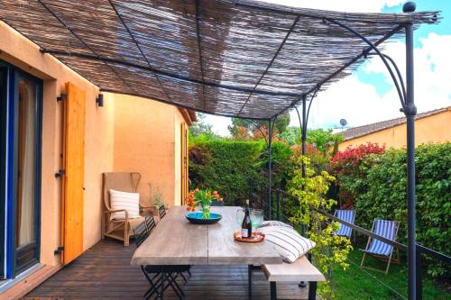 a patio with a table and chairs on a deck at La Maison Bleue in Rustrel