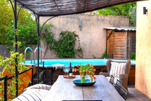 a patio with a table and a swimming pool at La Maison Bleue in Rustrel