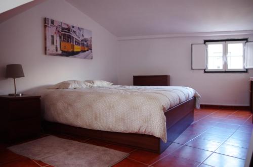 リスボンにあるLisbon Sloped Ceiling Apartmentのベッドルーム(ベッド1台、窓付)