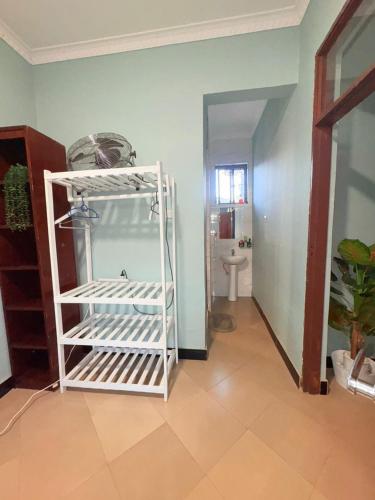 a room with a white gate and a bathroom at Maliasili Apartments in Mwanza
