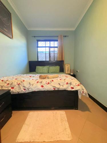 a bedroom with a large bed with a window at Maliasili Apartments in Mwanza