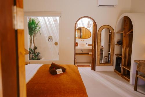 a bedroom with a bed and a large mirror at Luana Lombok in Selong Belanak