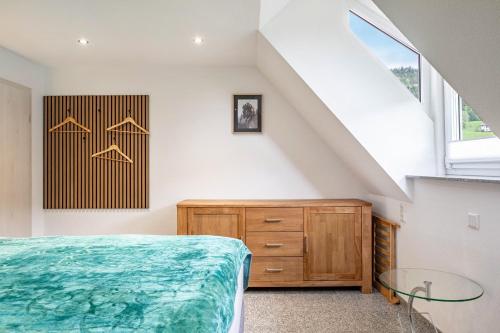 a bedroom with a bed and a dresser and a window at Ferienwohnung Schrödter in Schramberg