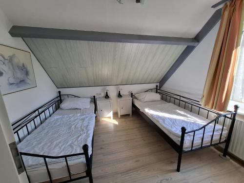 two twin beds in a room with a ceiling at Huus Kompass - Familienurlaub mit Hund nahe am Nordseestrand in Butjadingen