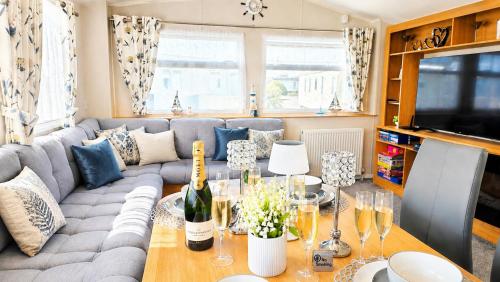 a living room with a couch and a table at Magic Caravan Camber Sands 221 in Camber