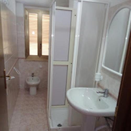 a white bathroom with a sink and a toilet at Residence Poseidon Villaggio in Isola Capo Rizzuto