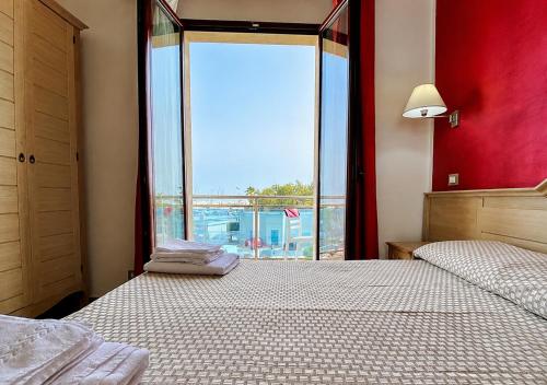a bedroom with two beds and a large window at B&B Marina Sleep And Ship in Rodi Garganico