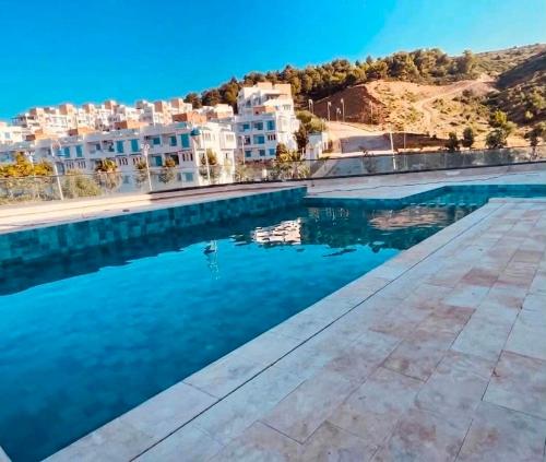a view of a pool of water with buildings at Prestige Stay a Perla Méditerranée avec Picine au Centre Mdiq in M'diq