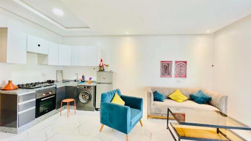 a kitchen and a living room with a couch and a table at Prestige Stay a Perla Méditerranée avec Picine au Centre Mdiq in M'diq