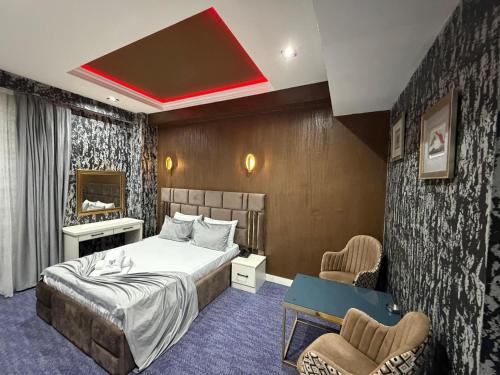 a hotel room with a bed and two chairs at Bazarstore Montin Hotel in Baku