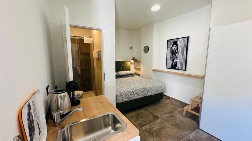 a bathroom with a sink and a bedroom with a bed at City Room Filip without window in Poreč