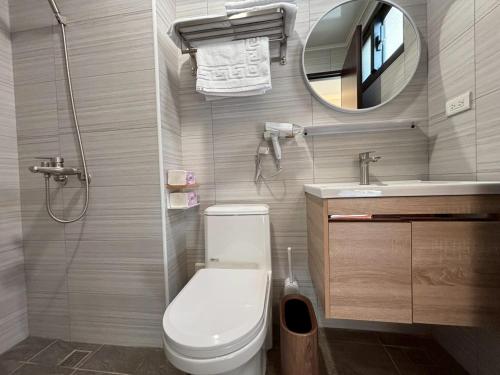 a bathroom with a toilet and a sink and a mirror at White in Gukeng