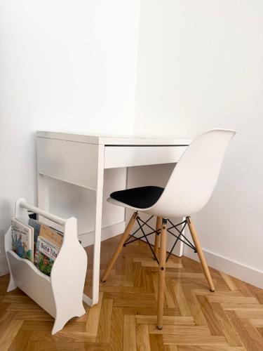 a white desk with a chair next to a book shelf at VUT Torreón de los Guzmanes in Ávila