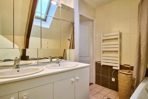 a bathroom with two sinks and a mirror at La Matheysiene in La Motte-dʼAveillans