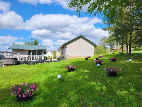 a yard with flowers and plants in the grass at Ritausmas Krasts in Plekšņi