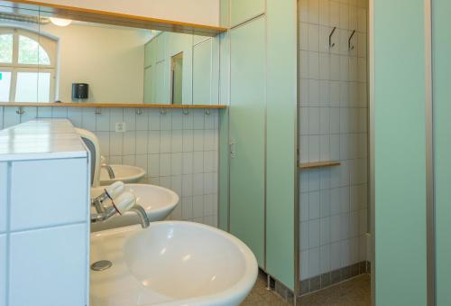 a bathroom with two sinks and two mirrors at Schaffhausen Youth Hostel in Schaffhausen
