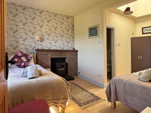 a bedroom with two beds and a fireplace at Cottage 507 - Renvyle in Renvyle